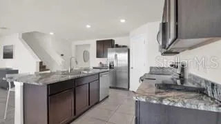 a kitchen with stainless steel appliances granite countertop a sink a stove and a refrigerator