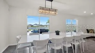 a dining room with furniture a chandelier and window