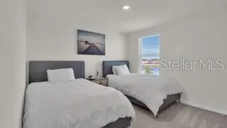 a bedroom with two beds and painting on the wall