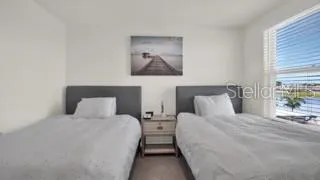 a bedroom with two beds and a painting on the wall