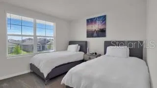 a bedroom with two beds and a large window