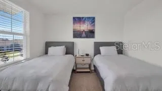 a bedroom with two beds and a large window