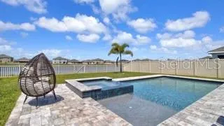 a view of a swimming pool with a patio and a yard