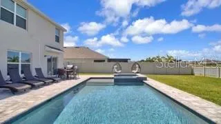 a view of a house with swimming pool and sitting area