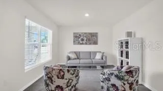 a living room with furniture a rug and a large window