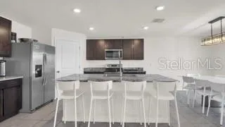 a kitchen with stainless steel appliances kitchen island granite countertop a refrigerator and a stove top oven
