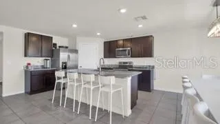 a kitchen with kitchen island granite countertop wooden cabinets and stainless steel appliances