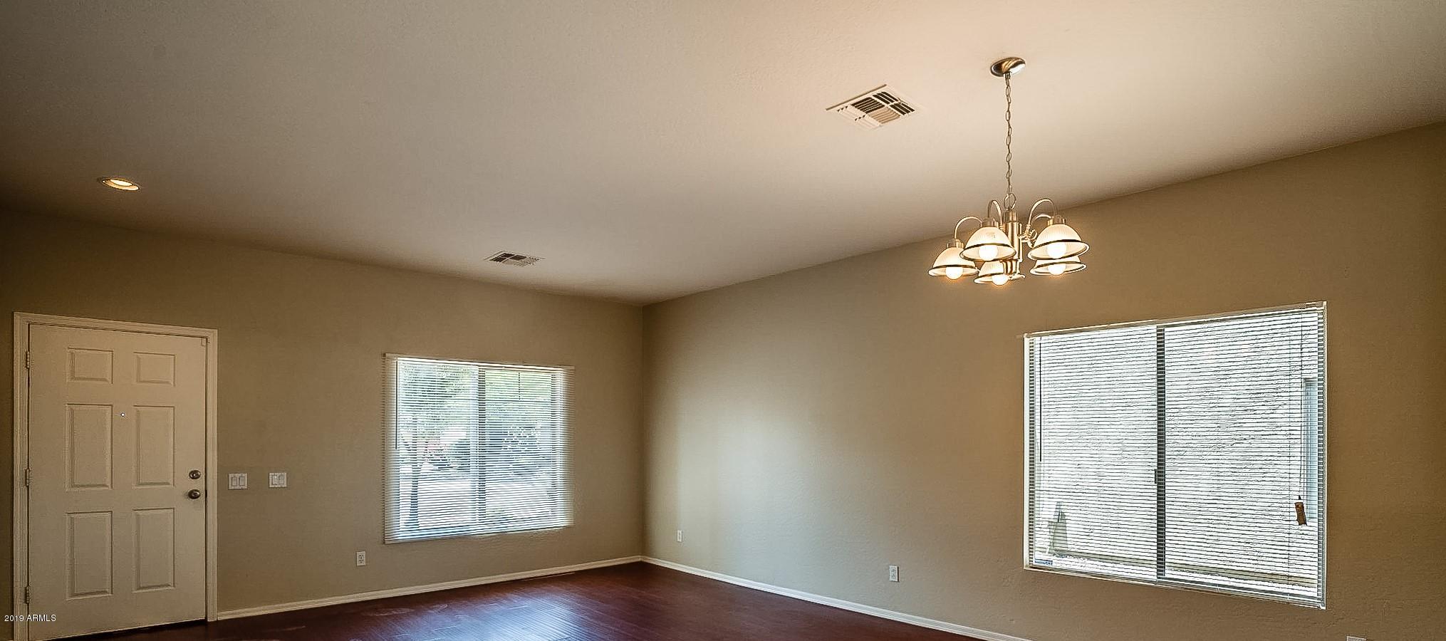 5118 West Apollo Road Laveen, AZ 85339 - Photo 8 of 57 a view of a livingroom with a chandelier fan and windows
