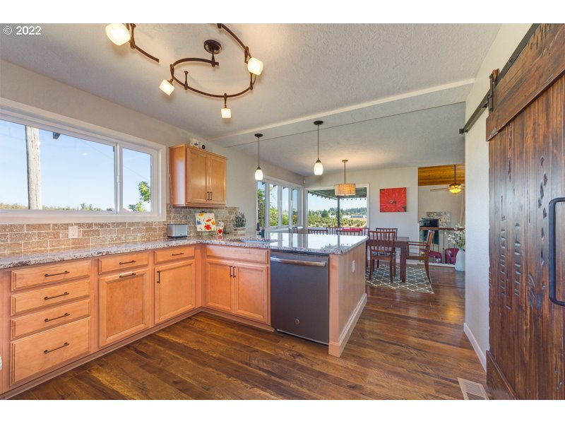 32000 Southwest Firdale Road Cornelius, OR 97123 - Photo 13 of 29 a kitchen with kitchen island granite countertop a sink cabinets and stainless steel appliances