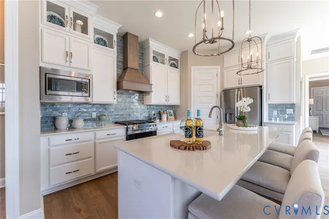 a kitchen with stainless steel appliances granite countertop a sink a stove and a cabinets