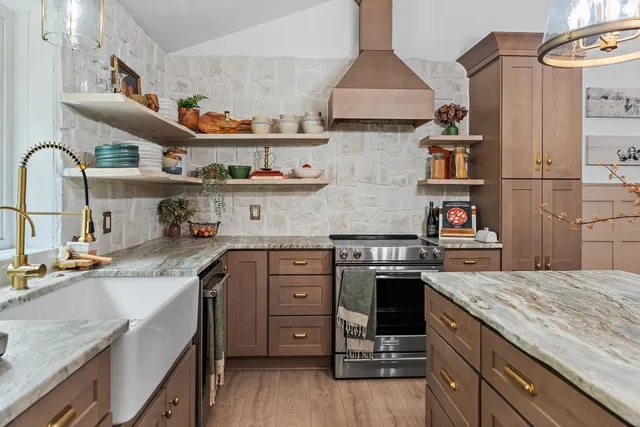 a kitchen with stainless steel appliances granite countertop a sink and a refrigerator