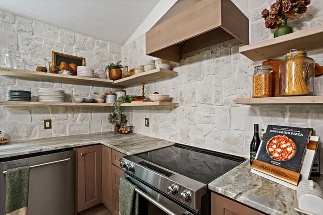 a dining room with stainless steel appliances granite countertop a table chairs and kitchen view