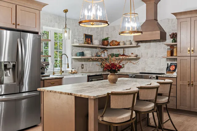 a kitchen with stainless steel appliances granite countertop a table chairs stove and refrigerator