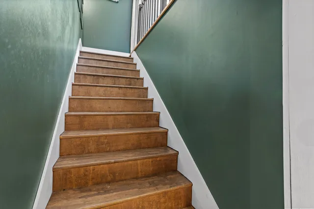 a view of a wooden house with a large tree and wooden fence