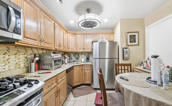 a kitchen with stainless steel appliances granite countertop a sink a stove and a refrigerator