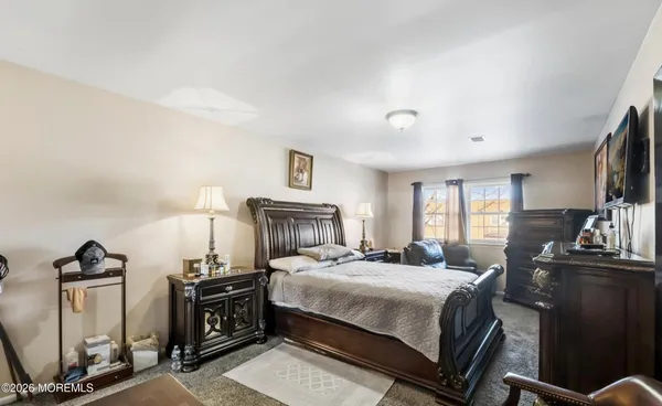 a bedroom with a bed and a flat tv screen on the dresser