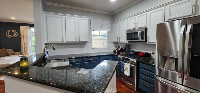 a kitchen with granite countertop a refrigerator stove and sink