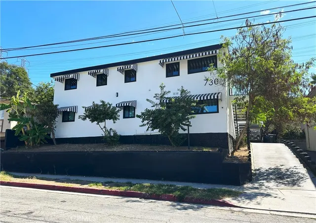 a front view of a house with plants