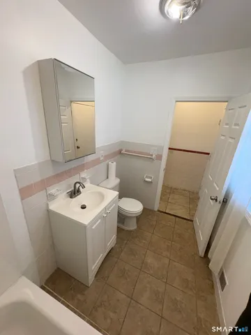 a bathroom with a sink a toilet and mirror