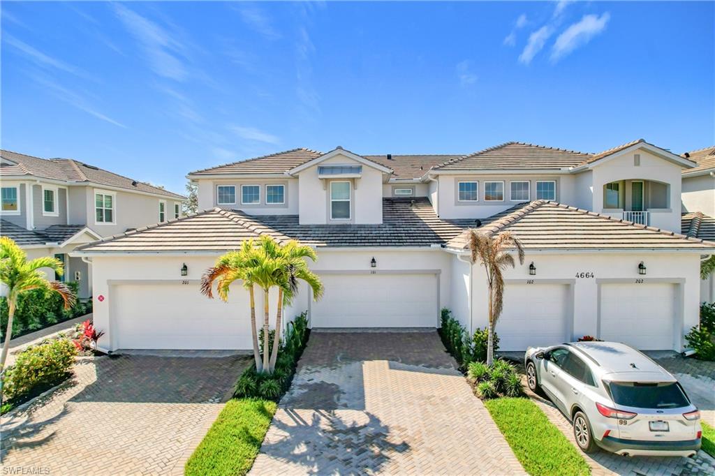 4664 Arboretum Circle, Unit 101 Naples, FL 34112 - Photo 1 of 48 a front view of a house with a garden
