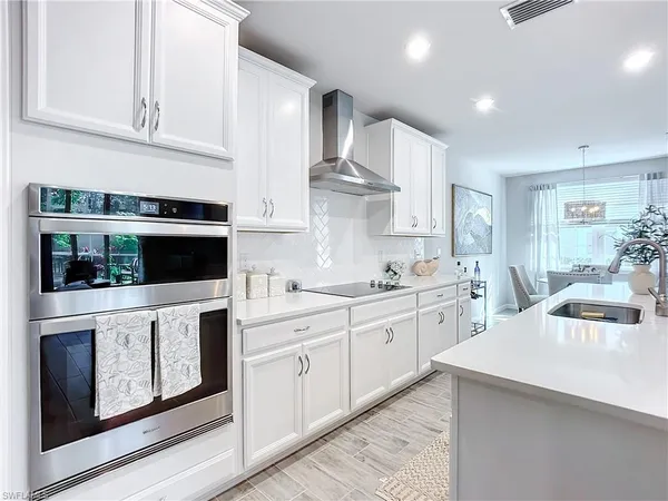a kitchen with white cabinets and white appliances