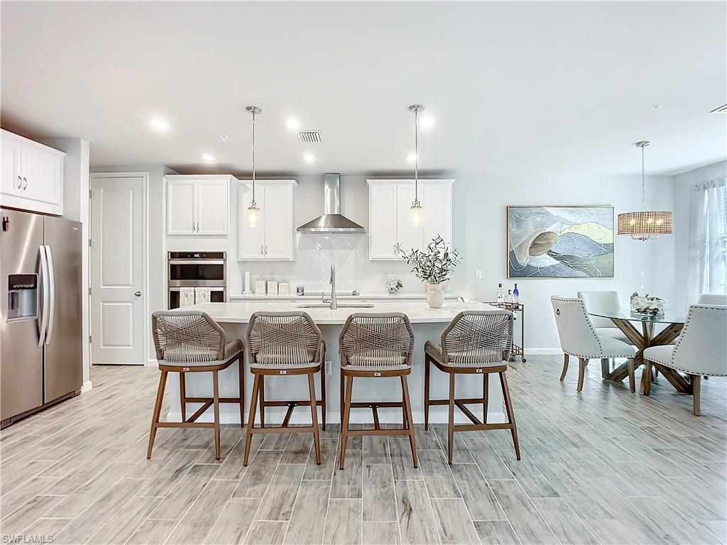 4664 Arboretum Circle, Unit 101 Naples, FL 34112 - Photo 13 of 48 a dining room with stainless steel appliances kitchen island granite countertop a dining table chairs and granite counter tops