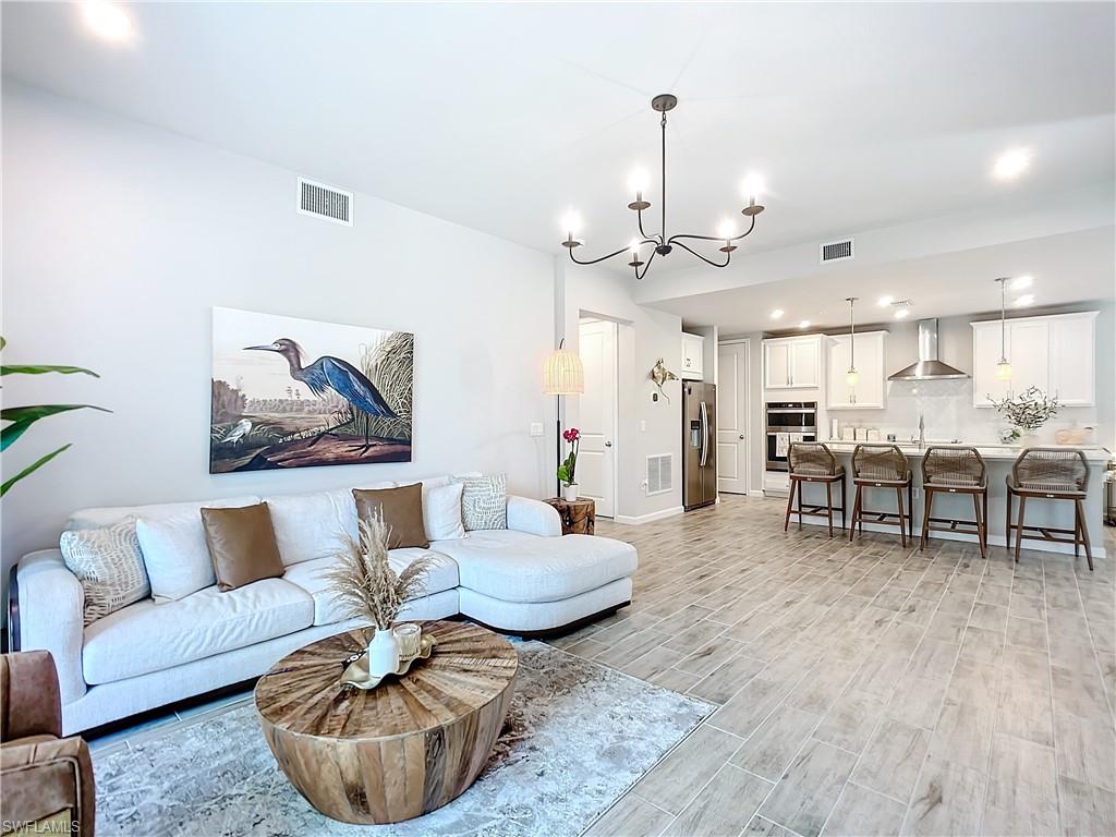4664 Arboretum Circle, Unit 101 Naples, FL 34112 - Photo 16 of 48 a living room with furniture and kitchen view