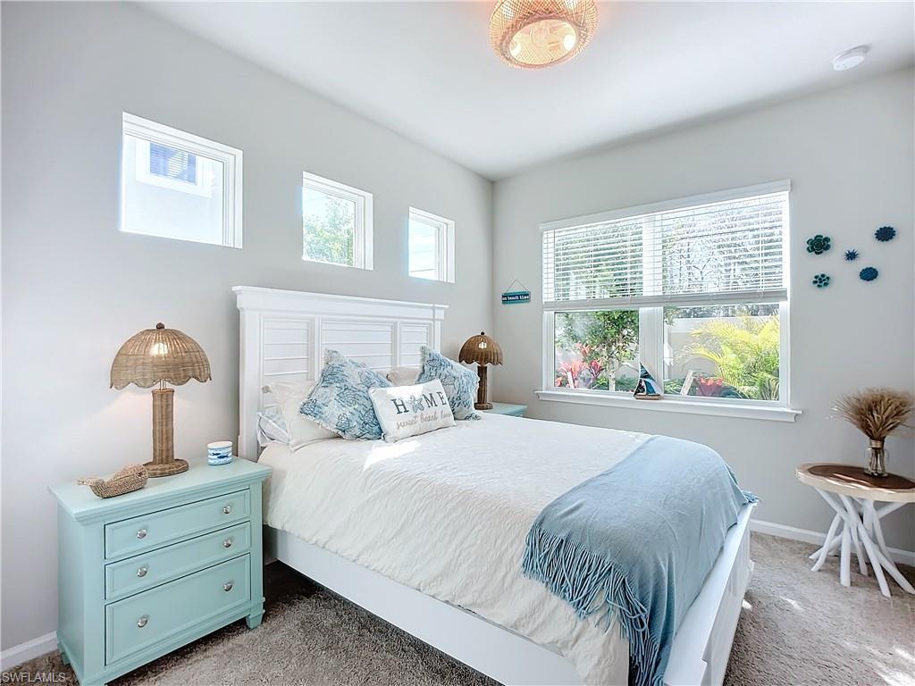 4664 Arboretum Circle, Unit 101 Naples, FL 34112 - Photo 19 of 48 a bedroom with a bed and a table