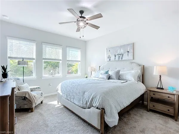 a bedroom with a bed a couch and a large window
