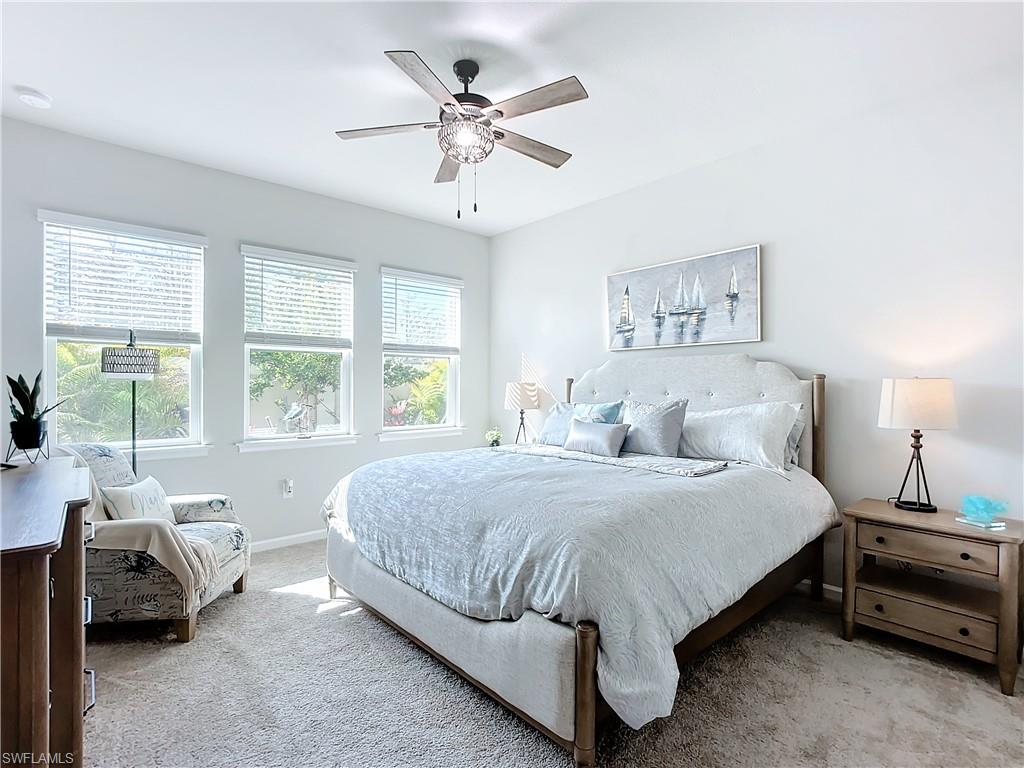 4664 Arboretum Circle, Unit 101 Naples, FL 34112 - Photo 25 of 48 a bedroom with a bed a couch and a large window