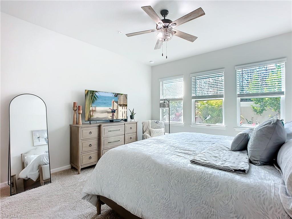 4664 Arboretum Circle, Unit 101 Naples, FL 34112 - Photo 26 of 48 a bedroom with a bed and a chandelier