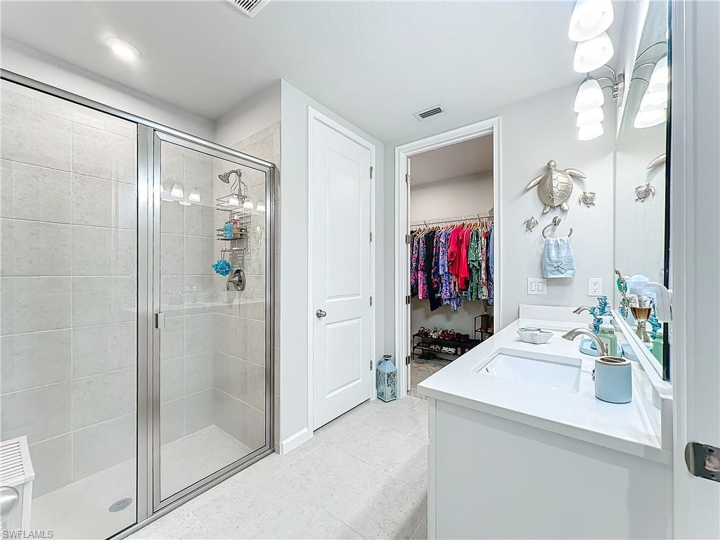 4664 Arboretum Circle, Unit 101 Naples, FL 34112 - Photo 27 of 48 a bathroom with a sink and a mirror