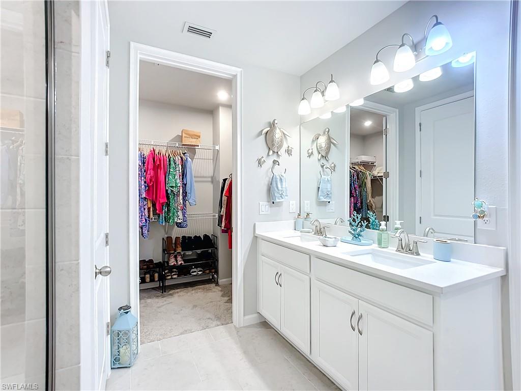 4664 Arboretum Circle, Unit 101 Naples, FL 34112 - Photo 31 of 48 a bathroom with a sink vanity and a mirror