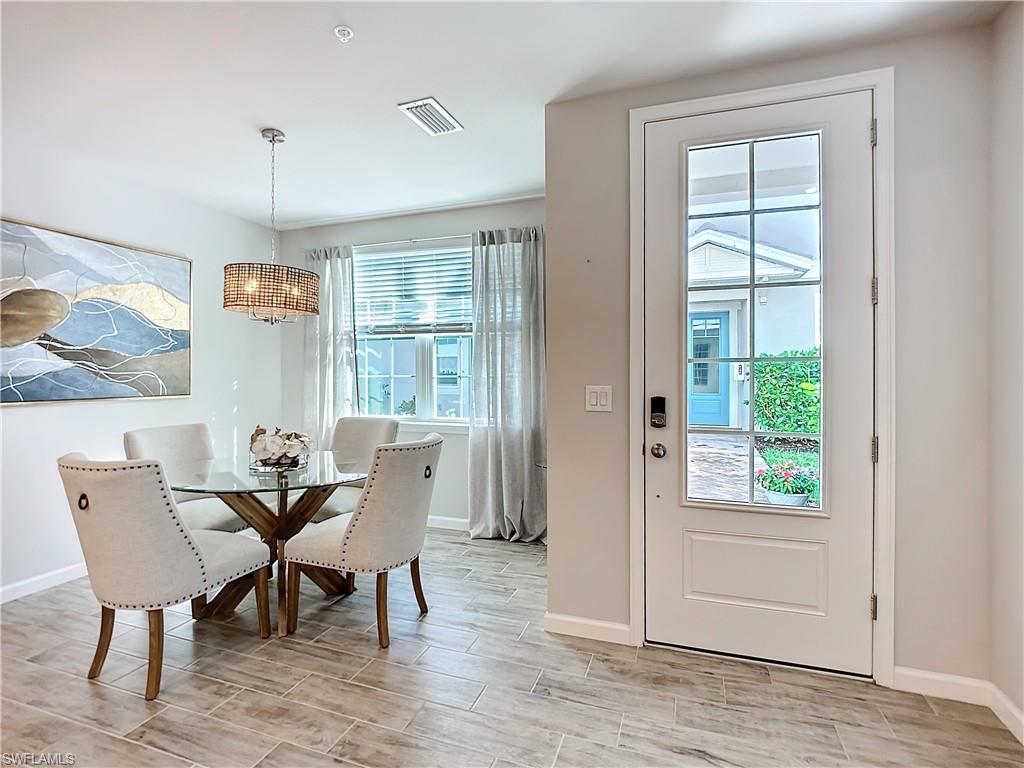 4664 Arboretum Circle, Unit 101 Naples, FL 34112 - Photo 6 of 48 a view of a dining room with furniture window and wooden floor