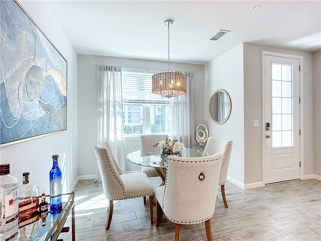 4664 Arboretum Circle, Unit 101 Naples, FL 34112 - Photo 7 of 48 a view of a dining room with furniture window and wooden floor
