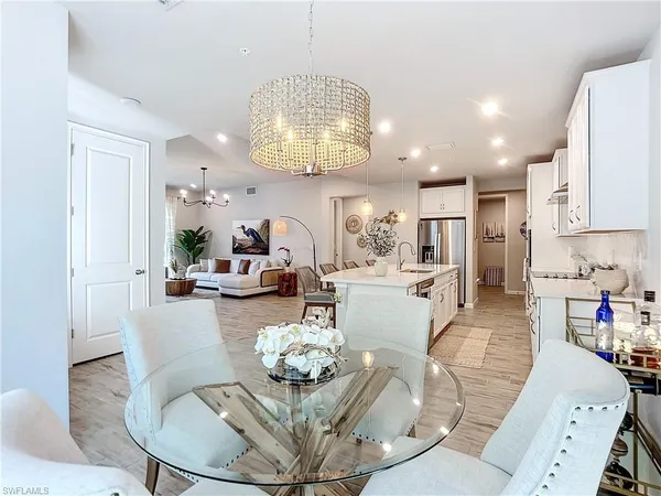 a living room with furniture kitchen and a chandelier