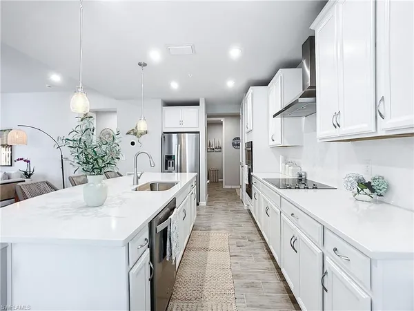 a large kitchen with kitchen island lots of counter space a sink appliances and cabinets