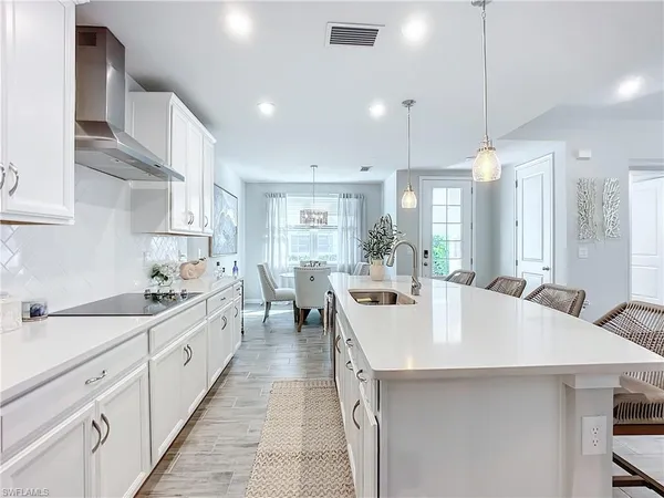 a large kitchen with kitchen island a sink a center island stainless steel appliances and cabinets