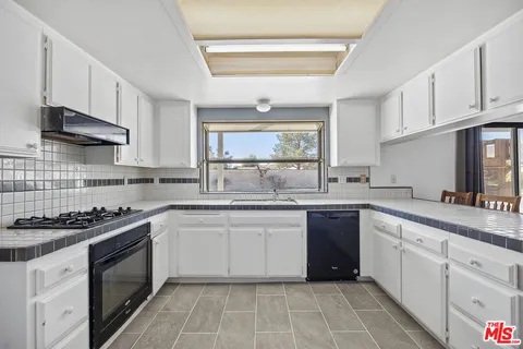 a kitchen with stainless steel appliances granite countertop a stove sink and cabinets