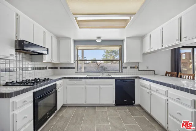 a kitchen with stainless steel appliances granite countertop a stove sink and cabinets