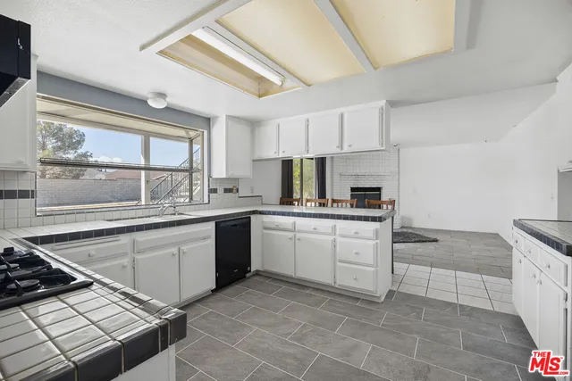 a kitchen with a sink stove and white cabinets