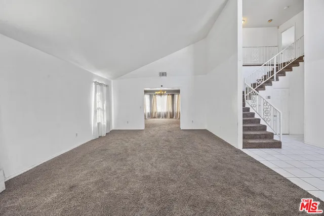 a view of an empty room with stairs and a fireplace