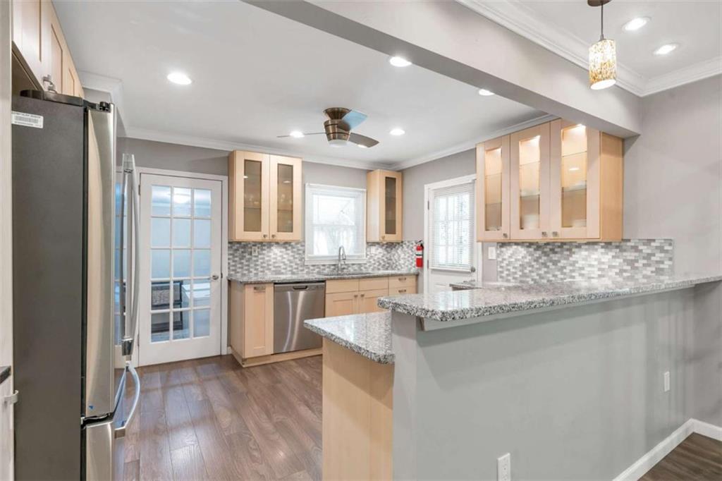 1766 Brewer Boulevard Southwest Atlanta, GA 30310 - Photo 5 of 30 a kitchen with stainless steel appliances granite countertop a sink cabinets and wooden floor