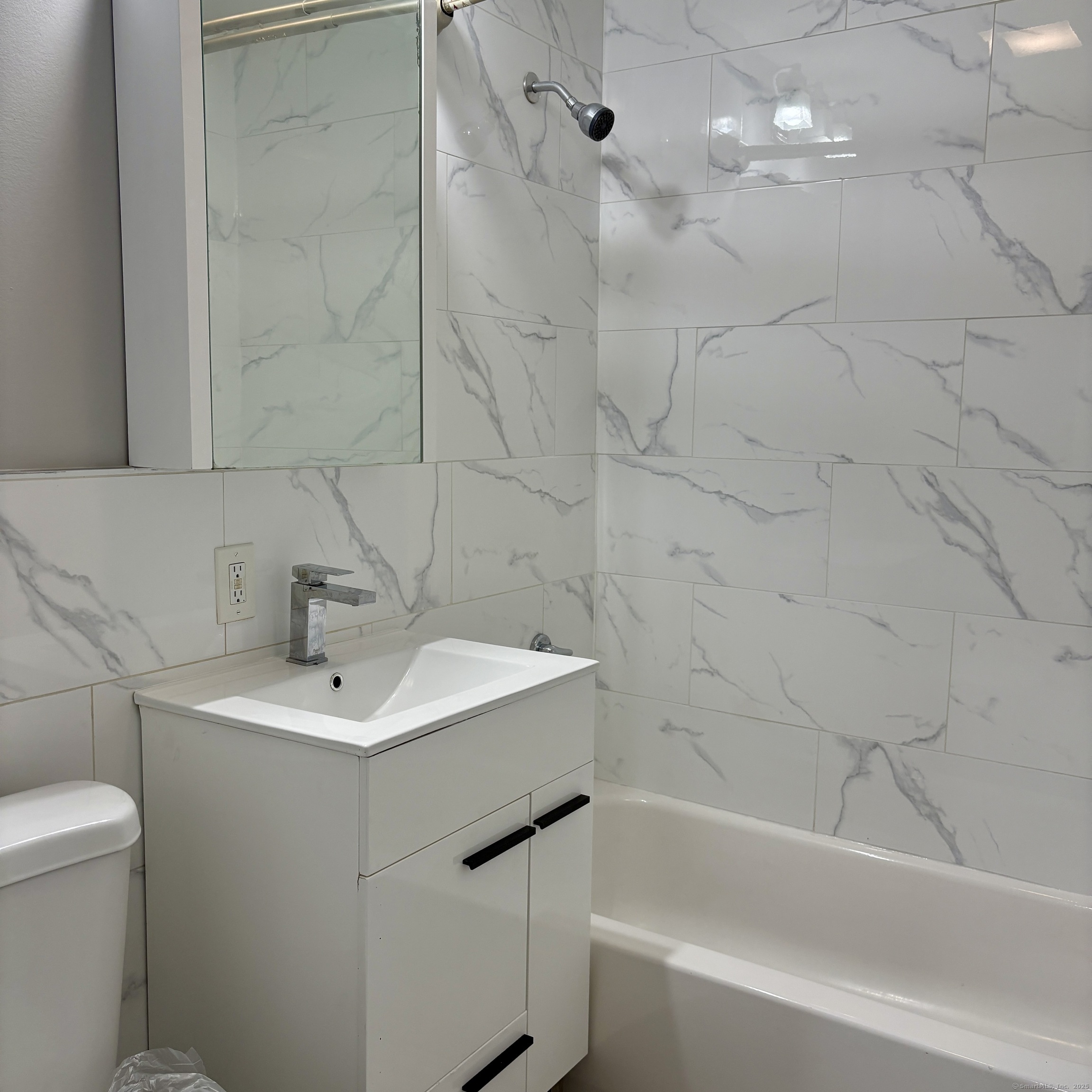 76 Commercial Street, Unit 1 Bridgeport, CT 06604 - Photo 6 of 9 a bathroom with a sink a toilet and shower