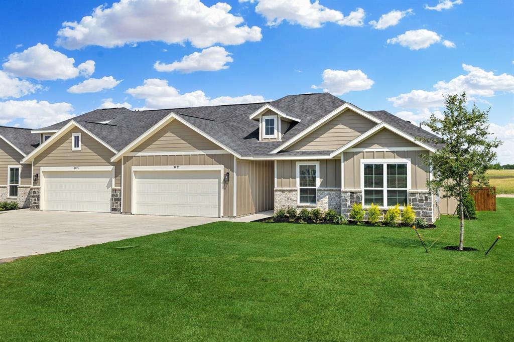 a front view of a house with a yard and trees