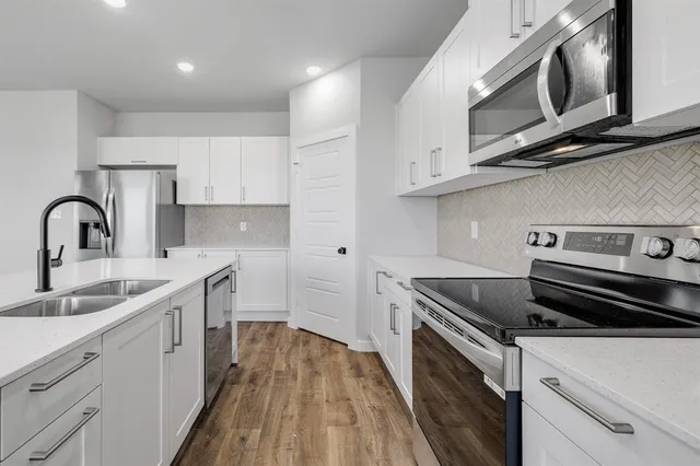 a kitchen with a sink stove and cabinets