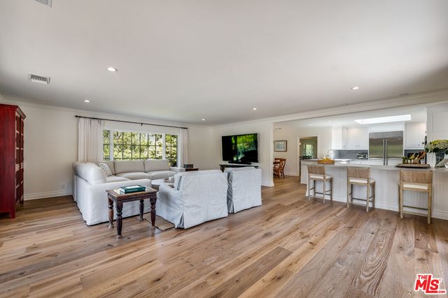 a kitchen with stainless steel appliances granite countertop a kitchen island a stove a table and a dining table