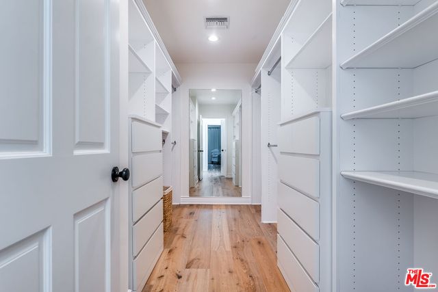 a spacious bedroom with a bed and wooden floor