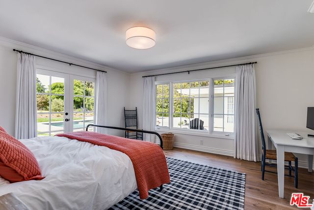 a bedroom with a bed and a large window