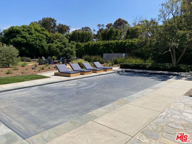 a view of a patio with dining table and chairs under an umbrella